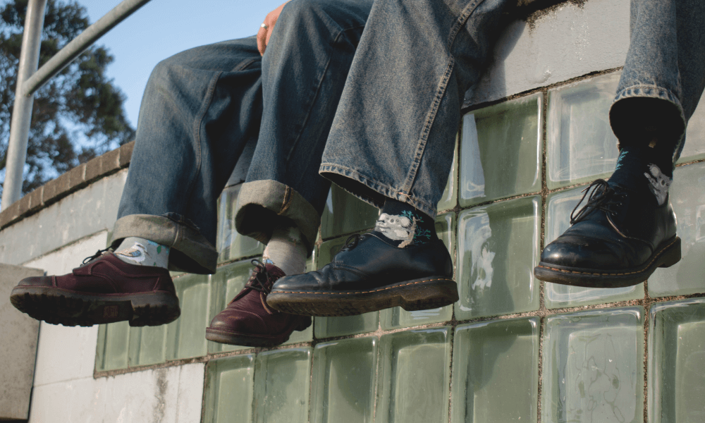 Young men sitting on a wall with their feet dangling